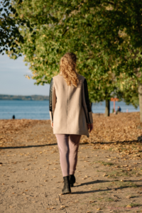 Femme marchant le long d’un chemin au bord de l’eau dans une ambiance paisible