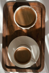 Deux tasses de café sur un plateau en bois illustrant un rituel de pause et de complicité dans le couple