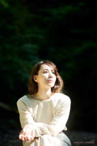 Femme assise dans la lumière naturelle, regard apaisé, illustration d’une pause émotionnelle pour réguler le système nerveux.